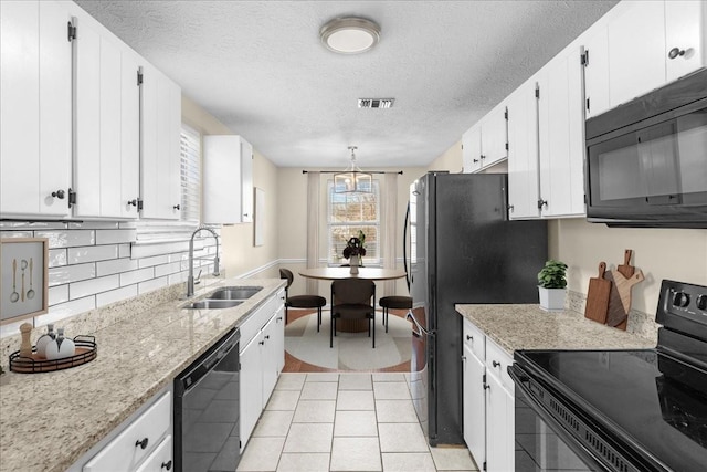 kitchen with black appliances, white cabinetry, sink, and a textured ceiling