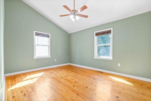 unfurnished room with wood-type flooring, vaulted ceiling, ceiling fan, and a healthy amount of sunlight