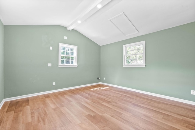 empty room featuring lofted ceiling with beams and light hardwood / wood-style floors