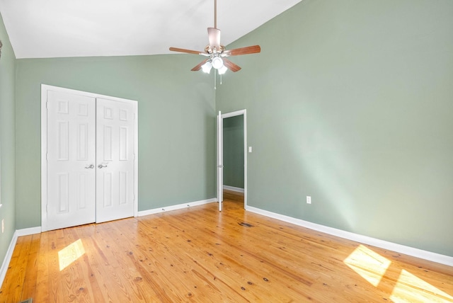 unfurnished bedroom with hardwood / wood-style floors, a closet, ceiling fan, and lofted ceiling