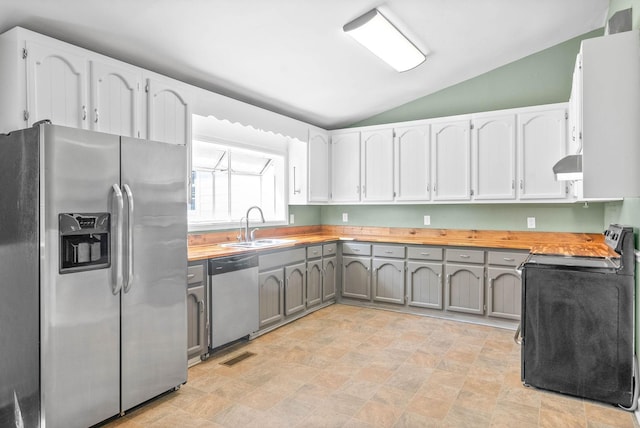 kitchen with exhaust hood, sink, gray cabinets, appliances with stainless steel finishes, and butcher block counters