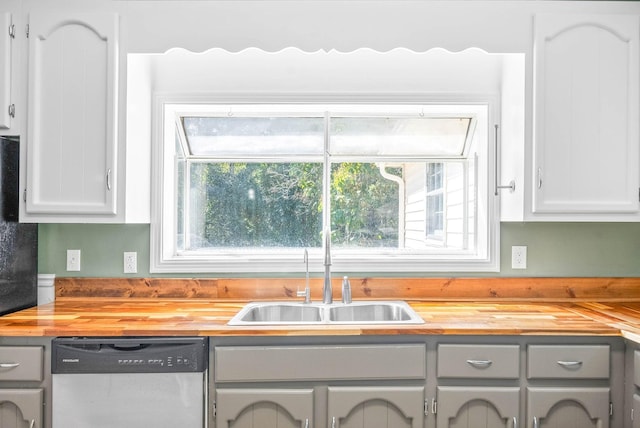 kitchen with gray cabinets, wooden counters, stainless steel dishwasher, and sink