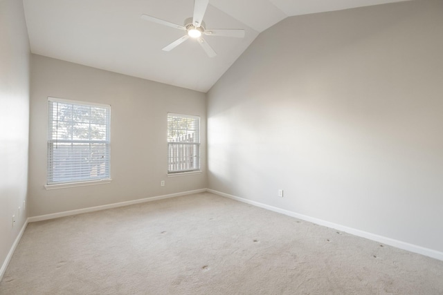 carpeted spare room featuring ceiling fan and vaulted ceiling