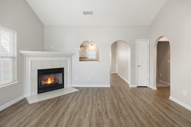 unfurnished living room with a fireplace, vaulted ceiling, and hardwood / wood-style flooring