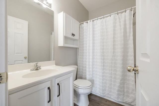 bathroom with hardwood / wood-style floors, vanity, curtained shower, and toilet