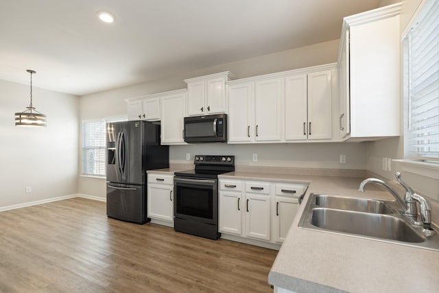 kitchen with pendant lighting, sink, white cabinets, and stainless steel appliances