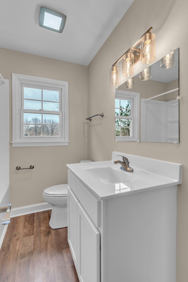 bathroom with a shower, hardwood / wood-style floors, vanity, and toilet