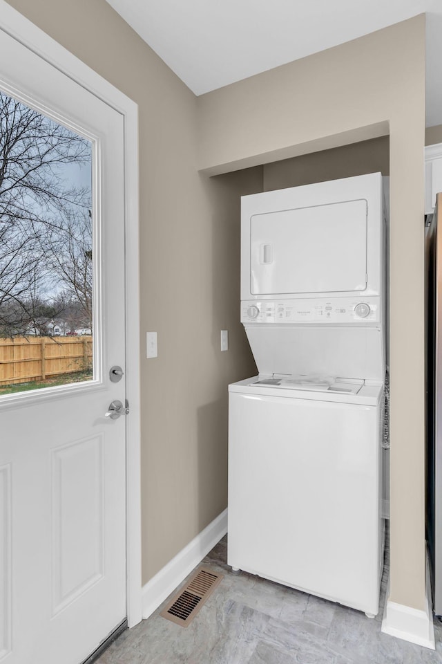 clothes washing area with stacked washer and dryer