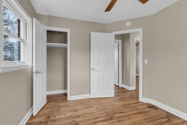 unfurnished bedroom featuring ceiling fan, a closet, and light hardwood / wood-style flooring