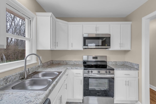 kitchen featuring white cabinetry, appliances with stainless steel finishes, and sink