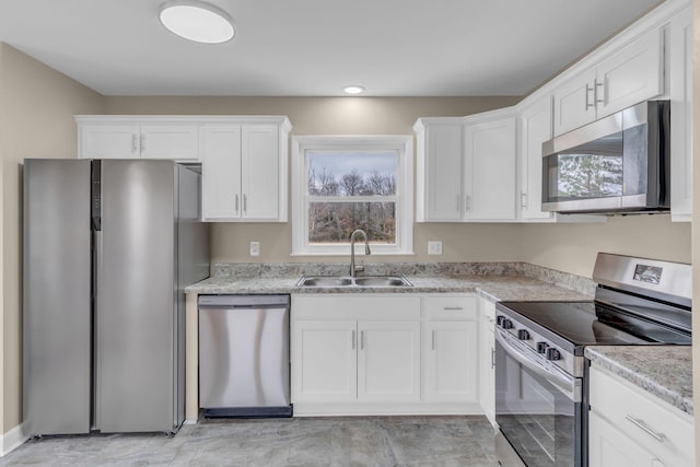 kitchen featuring appliances with stainless steel finishes, sink, and white cabinets