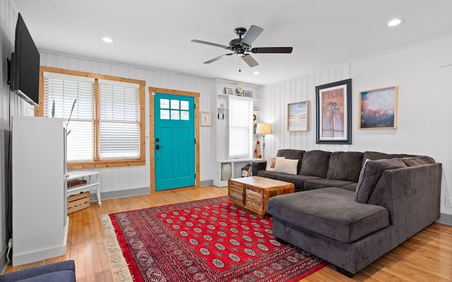 living room featuring ceiling fan, hardwood / wood-style floors, and ornamental molding