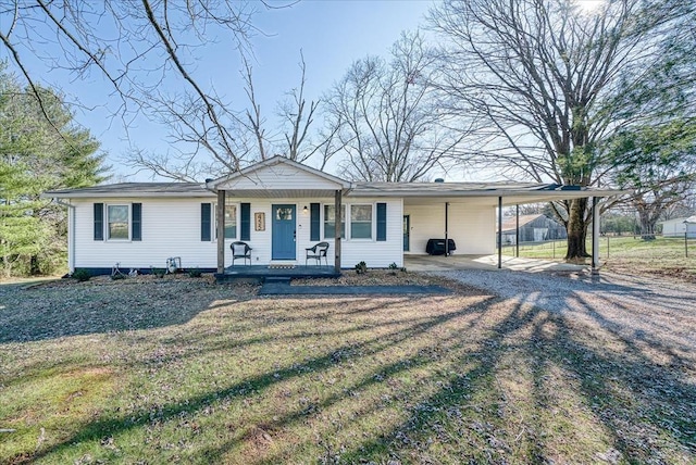 ranch-style house featuring a front lawn, covered porch, and a carport