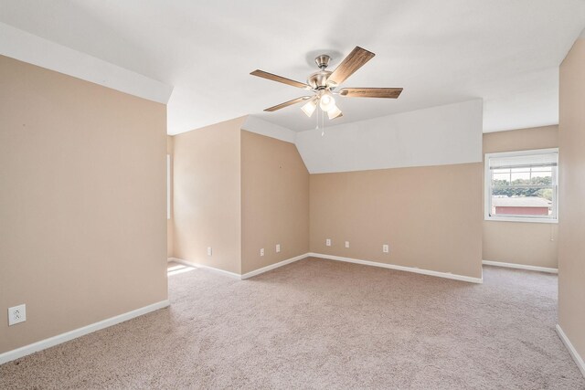 spare room with light carpet, ceiling fan, and lofted ceiling