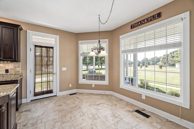 unfurnished dining area with a notable chandelier