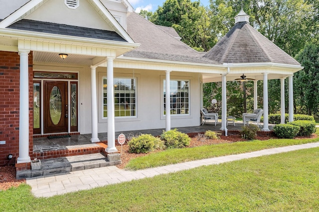 doorway to property featuring a porch and a yard