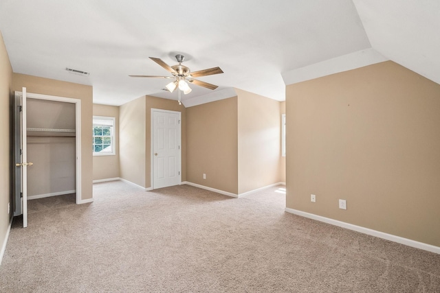 unfurnished bedroom with light carpet, vaulted ceiling, and ceiling fan