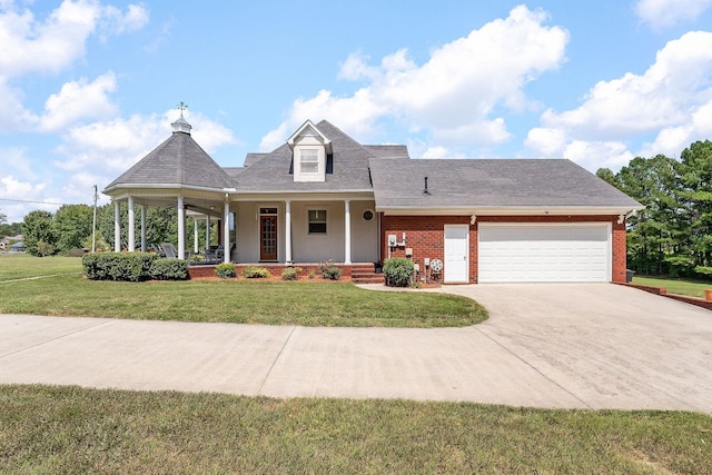 view of front of house featuring a porch, a garage, and a front lawn