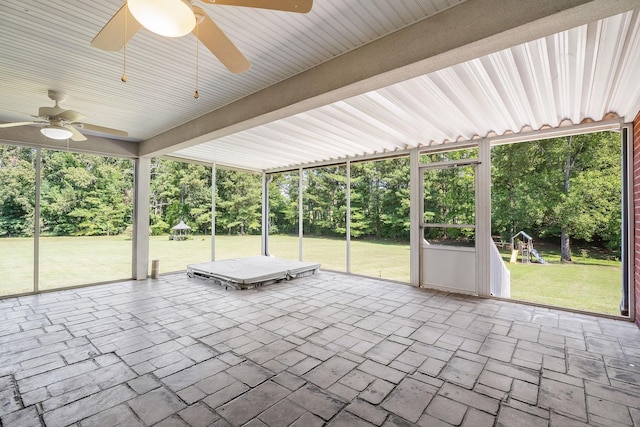 unfurnished sunroom with ceiling fan