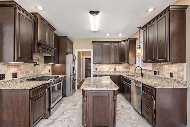 kitchen featuring pendant lighting, sink, dark brown cabinets, a kitchen island, and stainless steel appliances