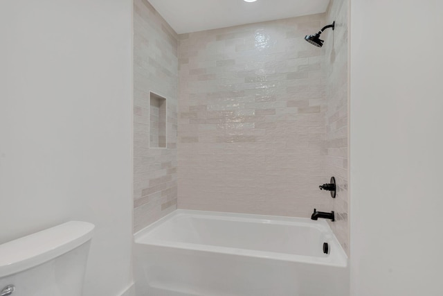 bathroom with toilet and tiled shower / bath