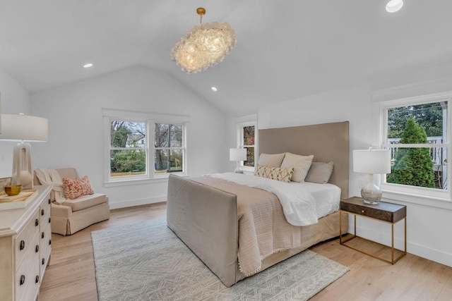 bedroom with a notable chandelier, lofted ceiling, and light hardwood / wood-style flooring