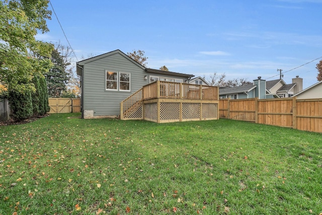 rear view of house featuring a yard and a wooden deck