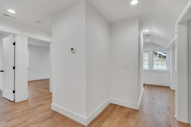 hall with lofted ceiling and light wood-type flooring