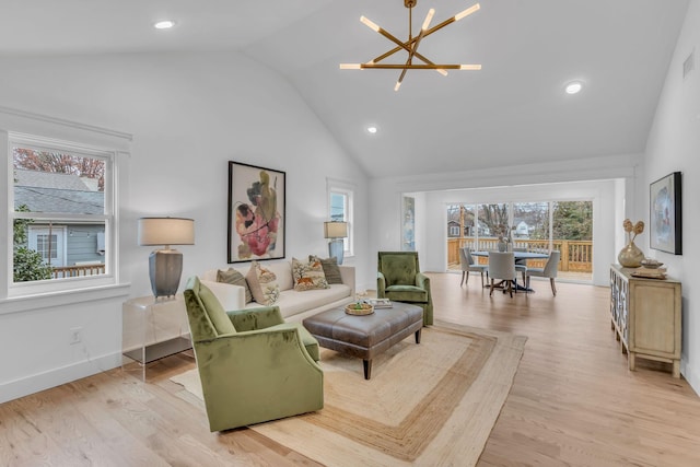 living room with a notable chandelier, light hardwood / wood-style floors, and vaulted ceiling