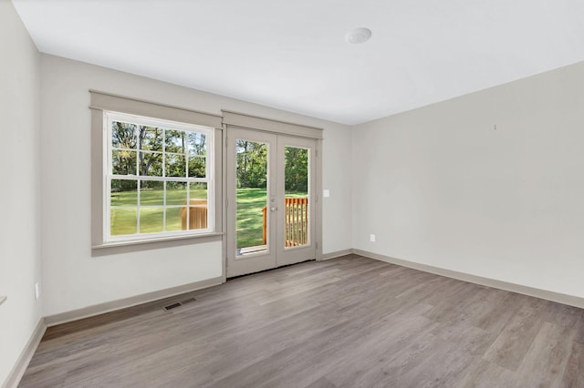 empty room featuring french doors and light hardwood / wood-style floors