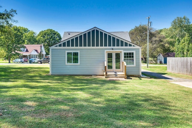 back of house featuring a lawn and french doors