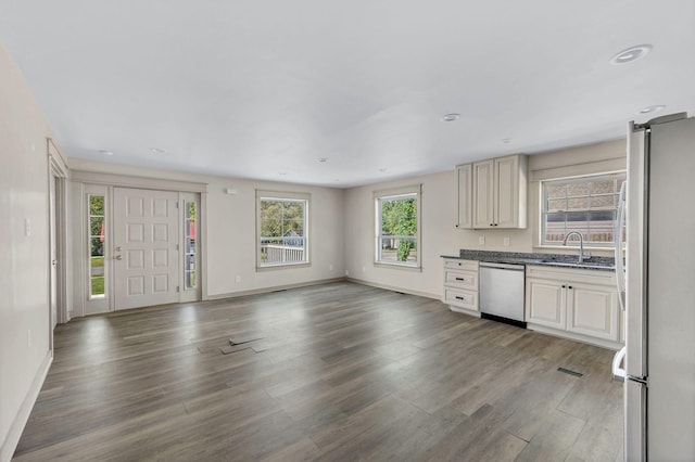 kitchen with appliances with stainless steel finishes, cream cabinets, dark wood-type flooring, and sink