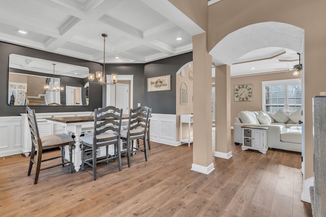 dining area with coffered ceiling, ceiling fan with notable chandelier, crown molding, beamed ceiling, and light hardwood / wood-style floors