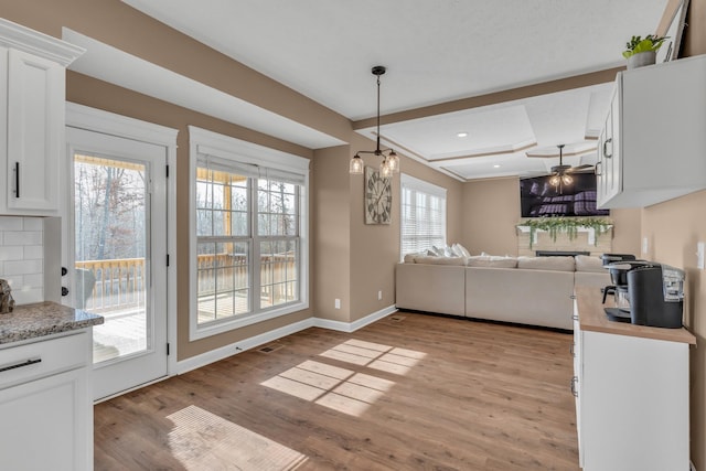 kitchen with beamed ceiling, light hardwood / wood-style floors, and white cabinetry