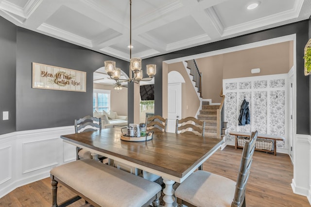 dining space featuring coffered ceiling, crown molding, ceiling fan, beamed ceiling, and light hardwood / wood-style floors