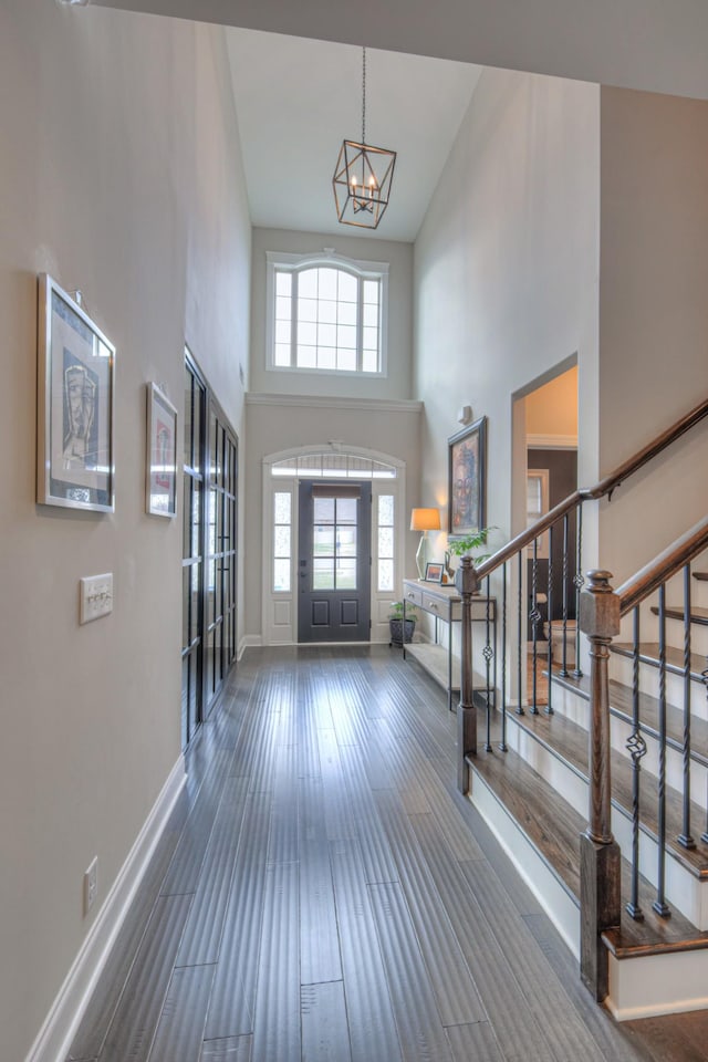 entrance foyer with a high ceiling, dark hardwood / wood-style floors, and a chandelier