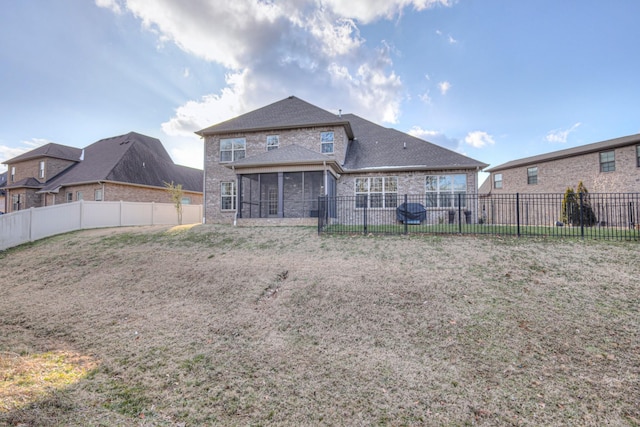 back of house with a sunroom and a lawn