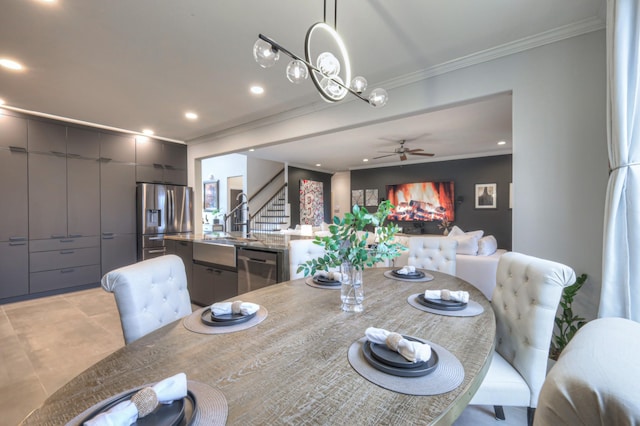 dining area with sink, crown molding, and ceiling fan