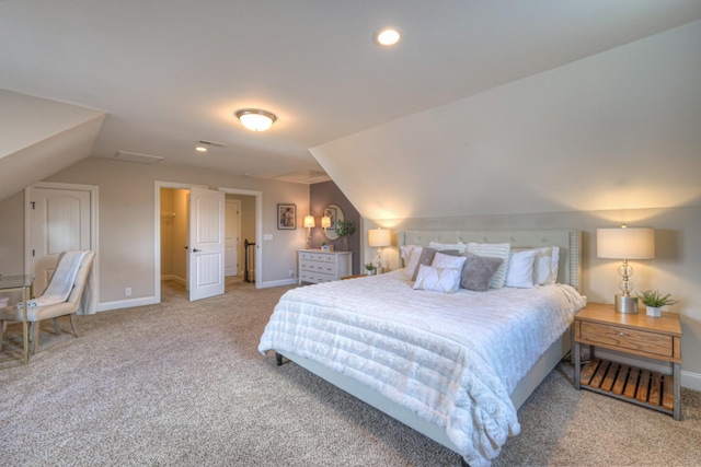 carpeted bedroom featuring vaulted ceiling and a walk in closet