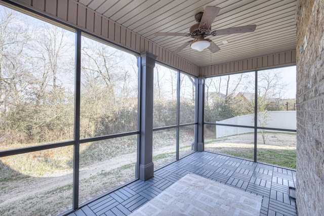 unfurnished sunroom with ceiling fan