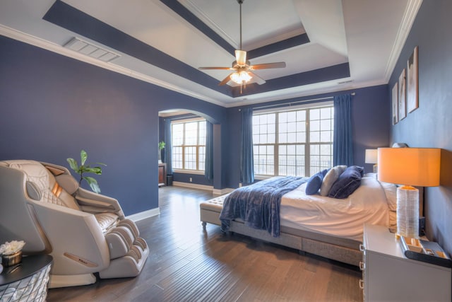 bedroom featuring a raised ceiling, crown molding, and dark wood-type flooring