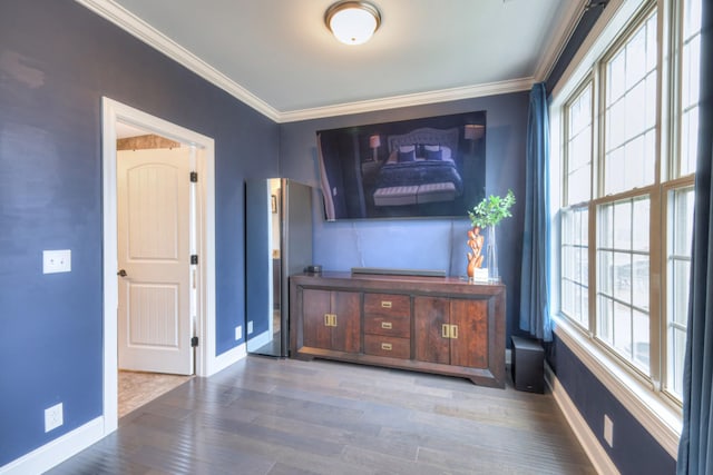 unfurnished living room featuring crown molding and hardwood / wood-style floors