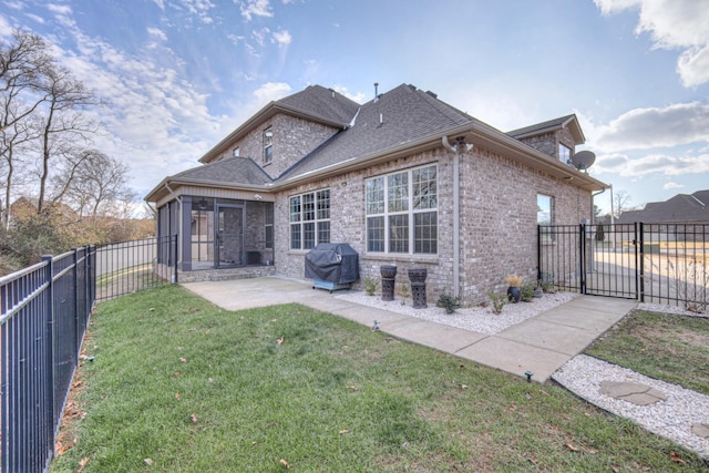 back of house with a patio area, a sunroom, and a lawn