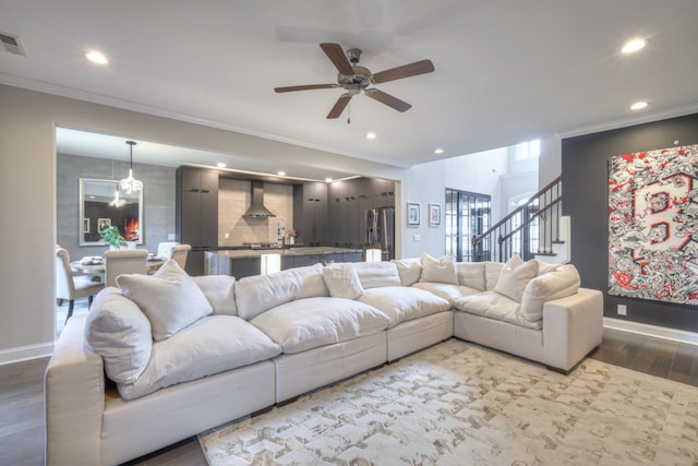 living room featuring ceiling fan, ornamental molding, and wood-type flooring