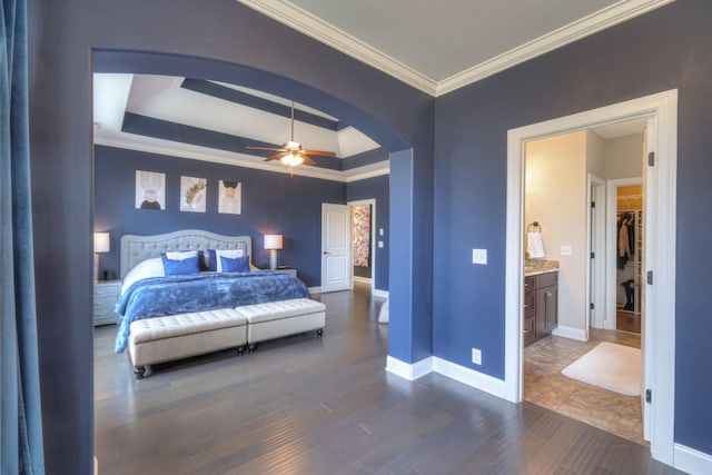 bedroom with a tray ceiling, crown molding, dark wood-type flooring, and ceiling fan