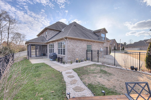 rear view of house featuring a lawn and a patio