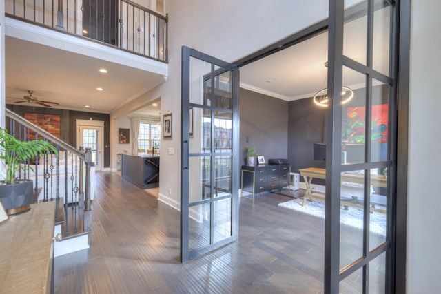 doorway to outside featuring dark hardwood / wood-style flooring, ornamental molding, and ceiling fan