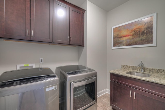 laundry area with cabinets, washer and clothes dryer, and sink