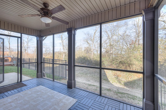 unfurnished sunroom with ceiling fan