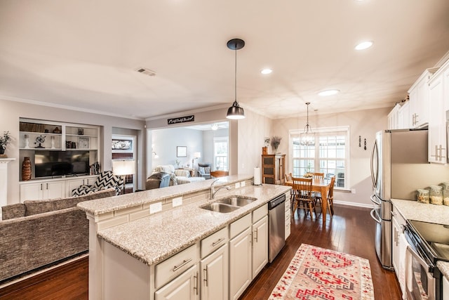 kitchen with sink, dark hardwood / wood-style floors, an island with sink, decorative light fixtures, and stainless steel appliances